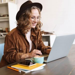 image-of-cheerful-woman-working-with-laptop-while-CNX4RJP.jpg
